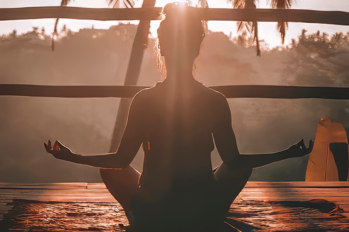 Sunrise yoga session on wooden deck overlooking tropical ocean